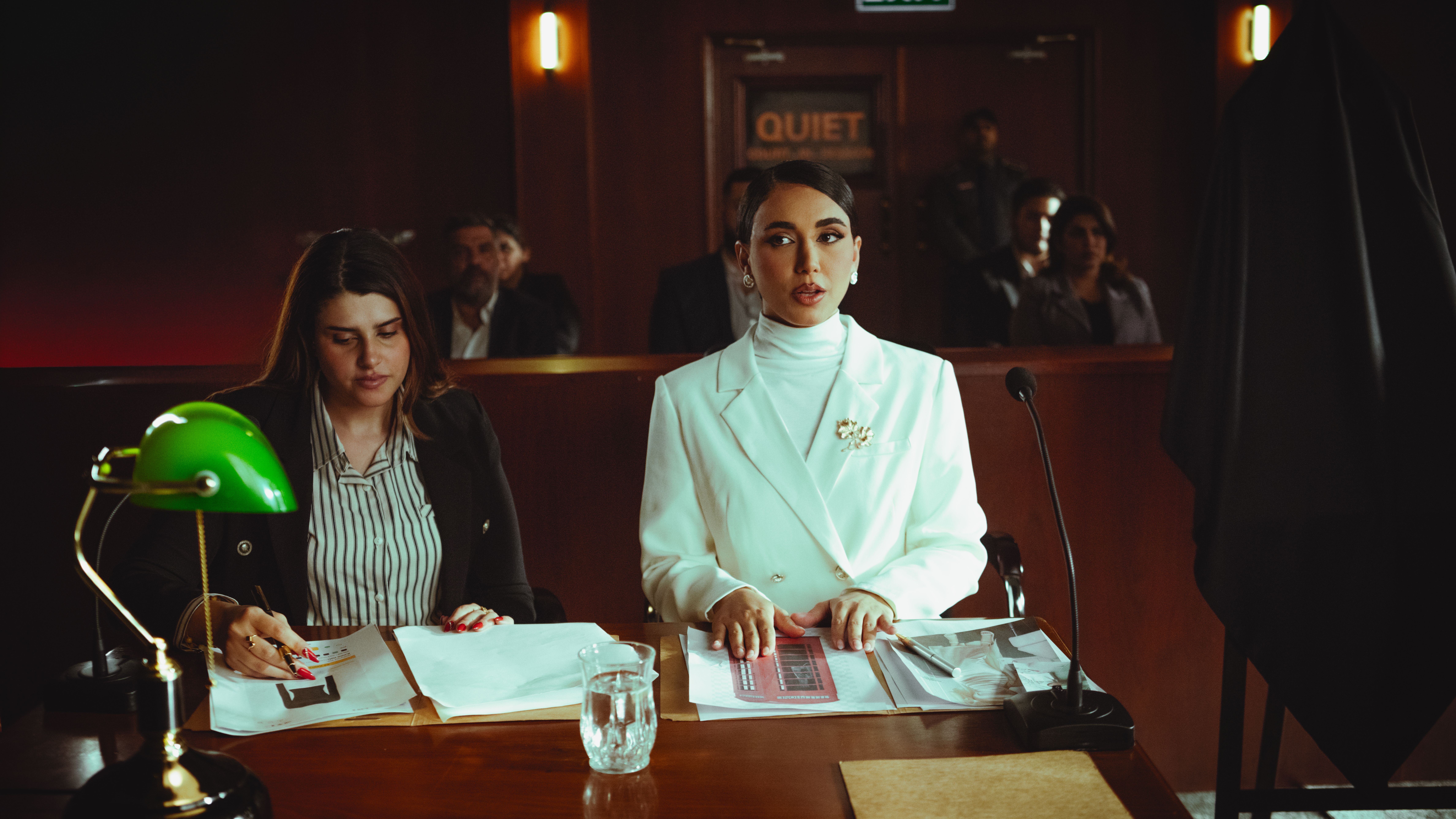 Two female lawyers presenting legal documents and arguments in a courtroom during trial