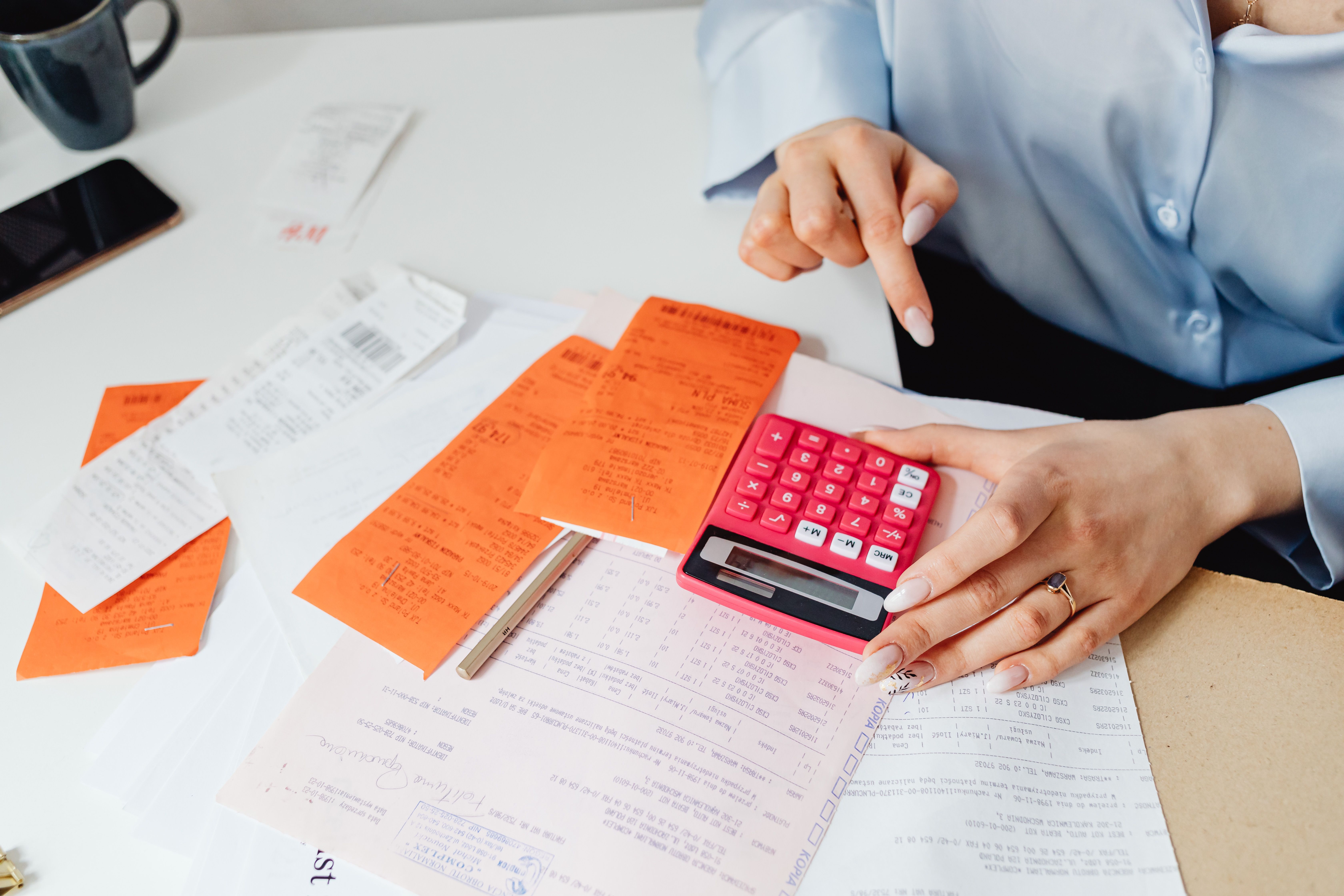 Business professional calculating expenses with receipts and a calculator