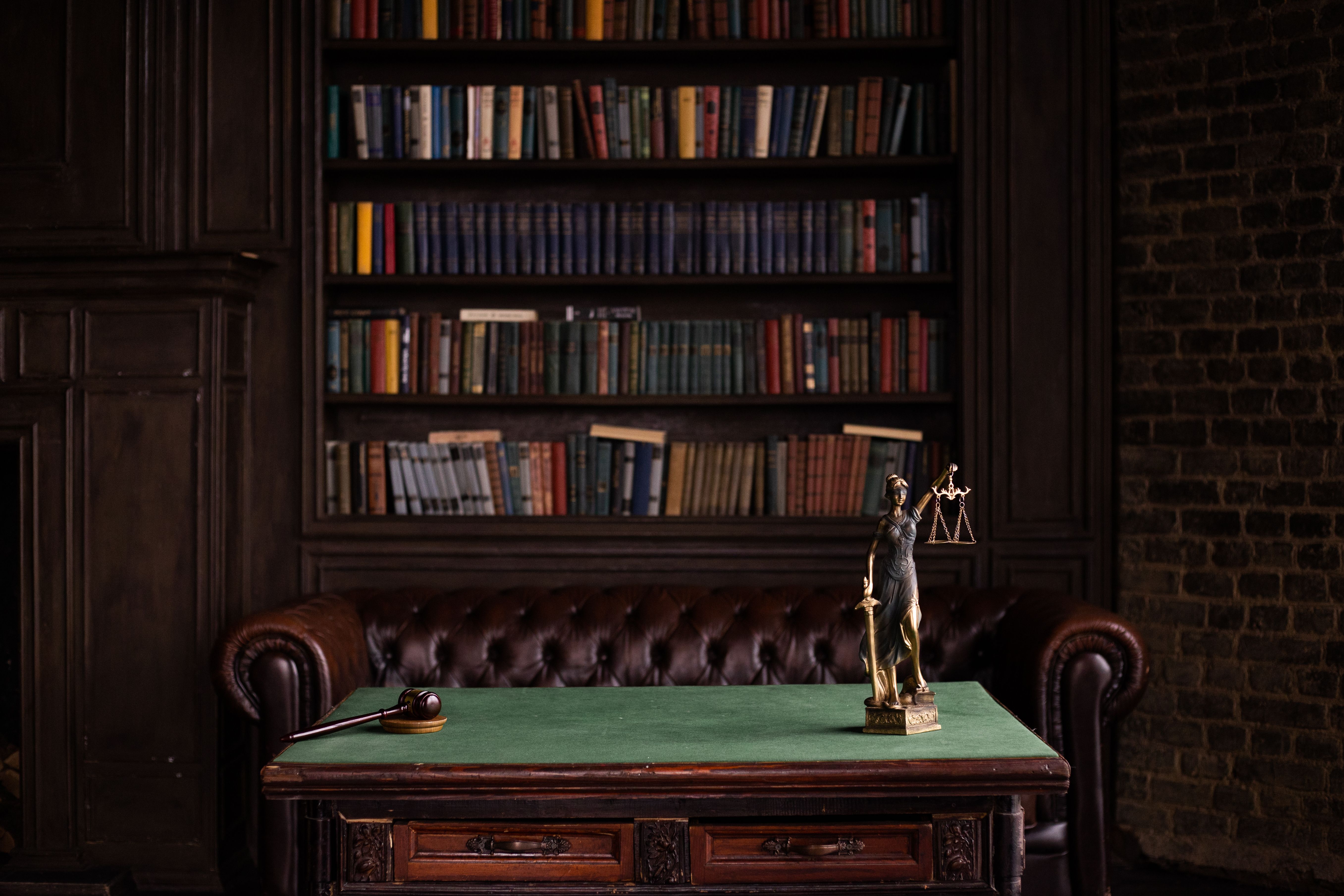 Law books, gavel, and Lady Justice figurine in a classic study