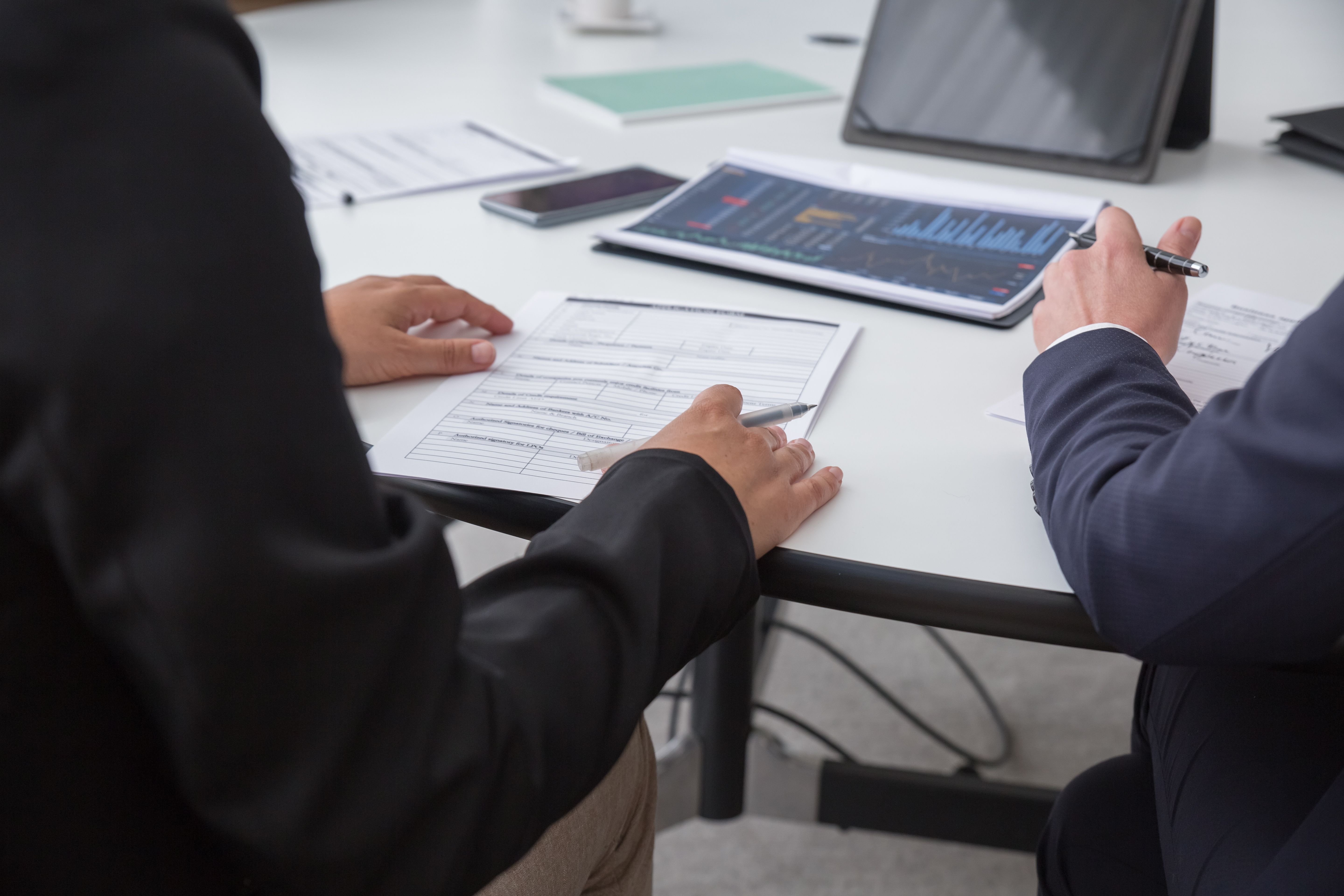 Close-up of professionals reviewing documents in an office setting